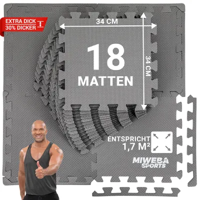 A man gives a thumbs up in front of a stack of grey puzzle mats.