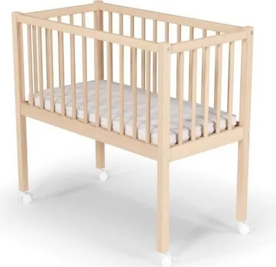 A light-colored wooden baby crib with a mattress and wheels, shown against a white background.