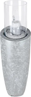 A close-up studio shot of a decorative floor column with a glass hurricane and a candle inside.