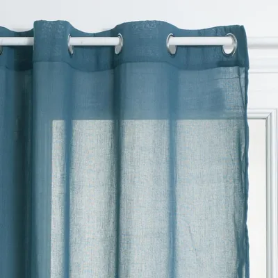 A close-up view of a blue curtain hanging from a white curtain rod.