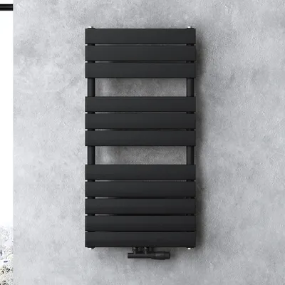 A black radiator is mounted on a concrete wall.