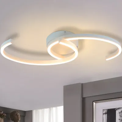 A modern white LED ceiling light fixture with swirling, ribbon-like arms, mounted on a white ceiling.