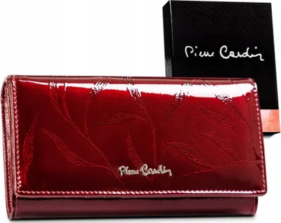 A red patent leather wallet with embossed leaf pattern and a Pierre Cardin logo, placed next to its branded box.
