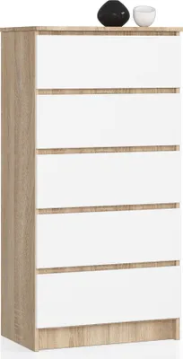 A tall, narrow chest of drawers with a wood-grain frame and white drawer fronts, shown against a white background. Two decorative spheres sit on top.