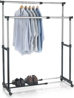 A double-tiered rolling garment rack with shirts hanging on the top rack and shoes on the bottom rack.