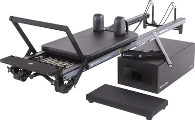 A Pilates reformer machine with accessories on a white background.