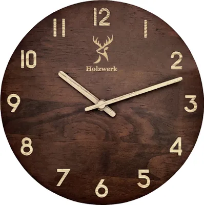 A close-up view of a wooden wall clock with a deer logo and the brand name 'Holzwerk'.