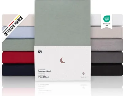 A stack of folded fitted sheets in various colors, with a product box in the foreground.