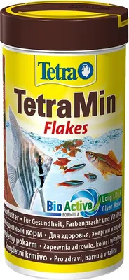 A product shot of TetraMin fish food flakes in a yellow and brown container.