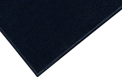 A close-up view of a dark blue rug, showing its texture and stitched edge.