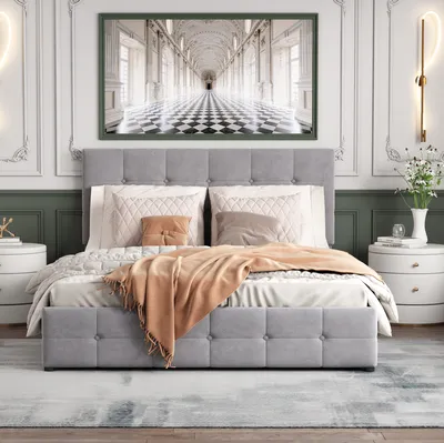 A bedroom scene featuring a bed with bedding and a large framed artwork above it.