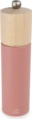 A pink pepper mill with a wooden top and a silver knob.