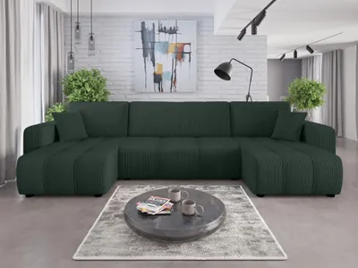 A large, dark green sectional sofa is arranged in a living room setting with a coffee table in front of it.