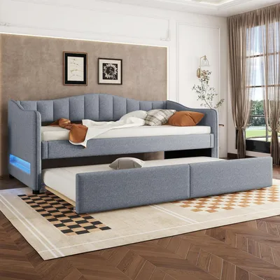 A modern bedroom with a gray upholstered daybed and a pull-out trundle bed.