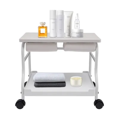 A beauty salon trolley with various cosmetic products and towels on it.