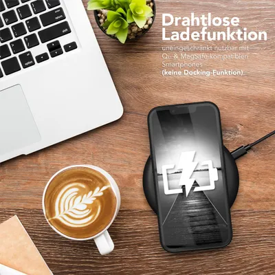A flat lay of a laptop, a cup of coffee, and a smartphone charging wirelessly on a wooden desk.