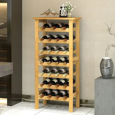A wooden wine rack filled with wine bottles, placed in a room with a neutral background.