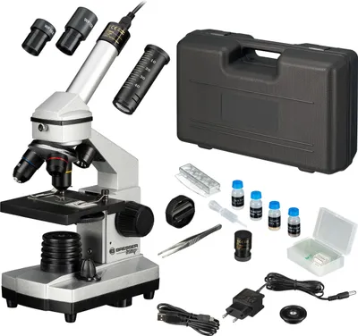 A Bresser junior microscope set with accessories and a carrying case, laid out on a white background.