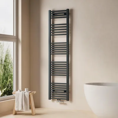 A modern bathroom with a towel radiator, a stool with towels, and a bathtub.
