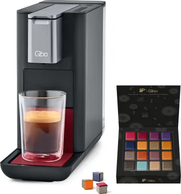A coffee machine with a glass of espresso and a box of coffee capsules.