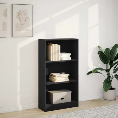 A black bookshelf with books and a box on it, placed against a white wall with shadows from sunlight.