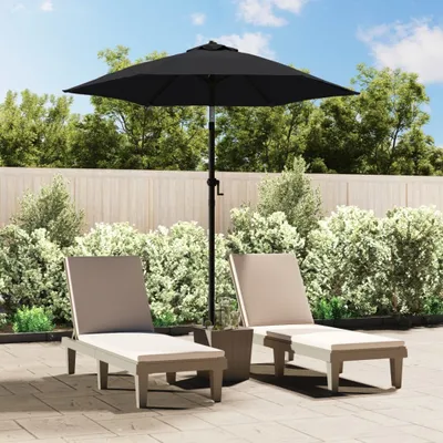 Two lounge chairs and a black umbrella are set up on a patio.