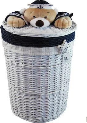 A white wicker laundry basket with a lid decorated with a plush bear wearing a navy blue sailor hat and matching cuffs.
