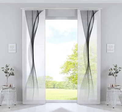Two panel curtains with a black wavy design are displayed in front of a window with a view of trees and sky.