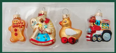 A set of four glass Christmas ornaments in a plastic tray.