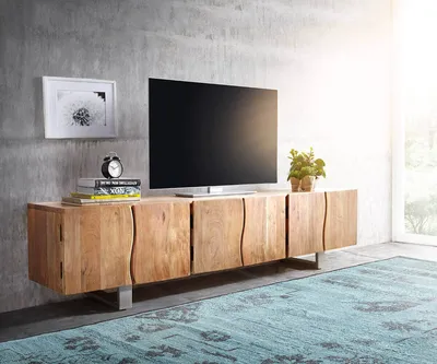 A modern living room with a wooden TV stand and a large television.
