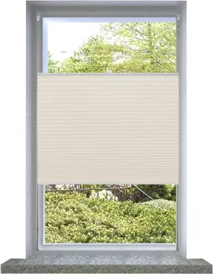 A cream-colored pleated blind is shown covering the lower half of a window, with greenery visible outside.