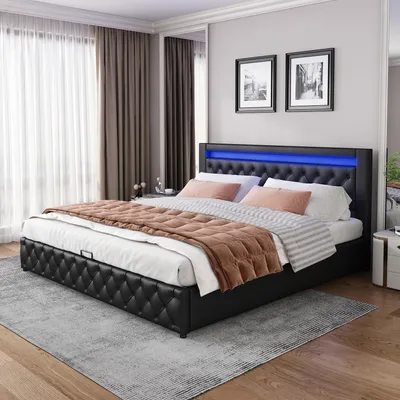A bedroom scene featuring a black upholstered bed with blue LED lighting.