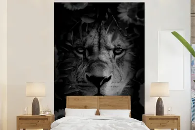 Produktbild von MuchoWow® Fototapete für Wohnzimmer oder Schlafzimmer Wandtapete Vinyl Motivtapete Nahaufnahme eines Löwen mit Blumen im Dschungel - schwarz und weiß - 195x300 cm - Das Hintergrundbild