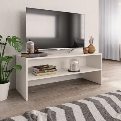 A white TV stand with a television and decorative items.