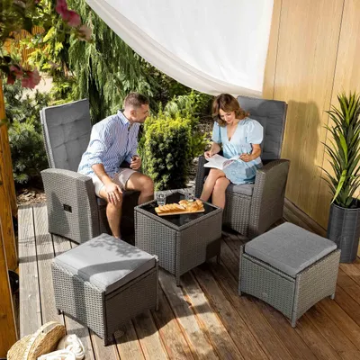 A couple relaxing on a patio with outdoor furniture.