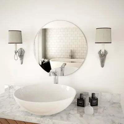 A modern bathroom vanity with a round mirror, a vessel sink, and two wall sconces.
