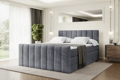 A bedroom scene featuring a large, upholstered bed.