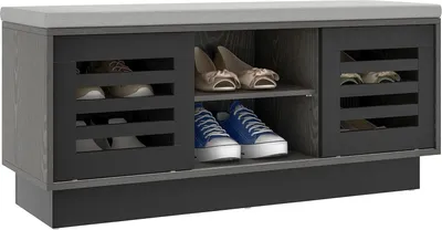 A shoe bench with storage compartments and a cushioned top, displaying shoes inside.