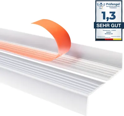 A close-up of a transparent stair edge protector with an orange peel-away adhesive strip. A German quality seal is visible in the upper right corner.