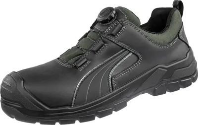 A single black safety shoe with green accents is shown against a white background.
