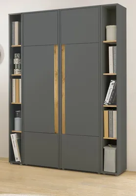 A modern gray wardrobe with wooden handles and open shelving units on the sides, displaying books and decorative items.