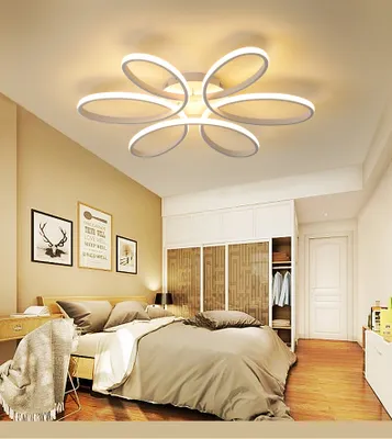 A bedroom with a bed, wardrobe, and a modern ceiling light.