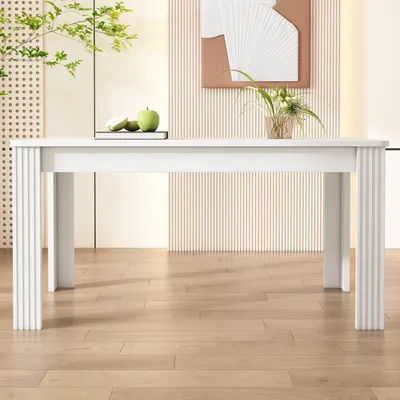 A white rectangular dining table with decorative legs is shown in a well-lit room with a wooden floor and a textured wall.