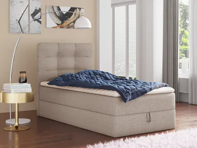 A bedroom scene with a bed, side table, and lamp.
