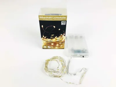 A product shot of a string of LED lights, its packaging, and battery pack, arranged on a white background.