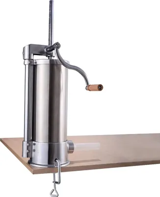 A stainless steel sausage stuffer is clamped to a wooden surface.