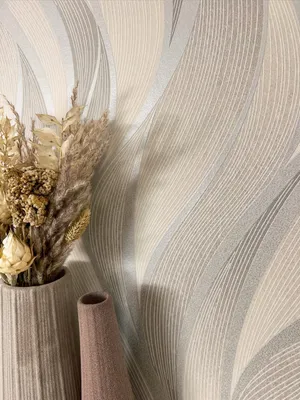 A close-up of a wallpaper with a wavy pattern, featuring a vase with dried flowers.