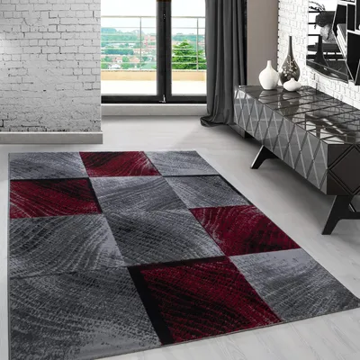 A modern living room with a geometric patterned rug in the foreground and a dark wood cabinet with decorative vases in the background.