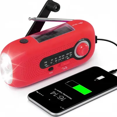 A red emergency radio is shown charging a smartphone.
