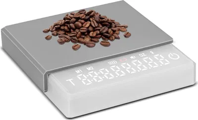 A digital scale with coffee beans on top.
